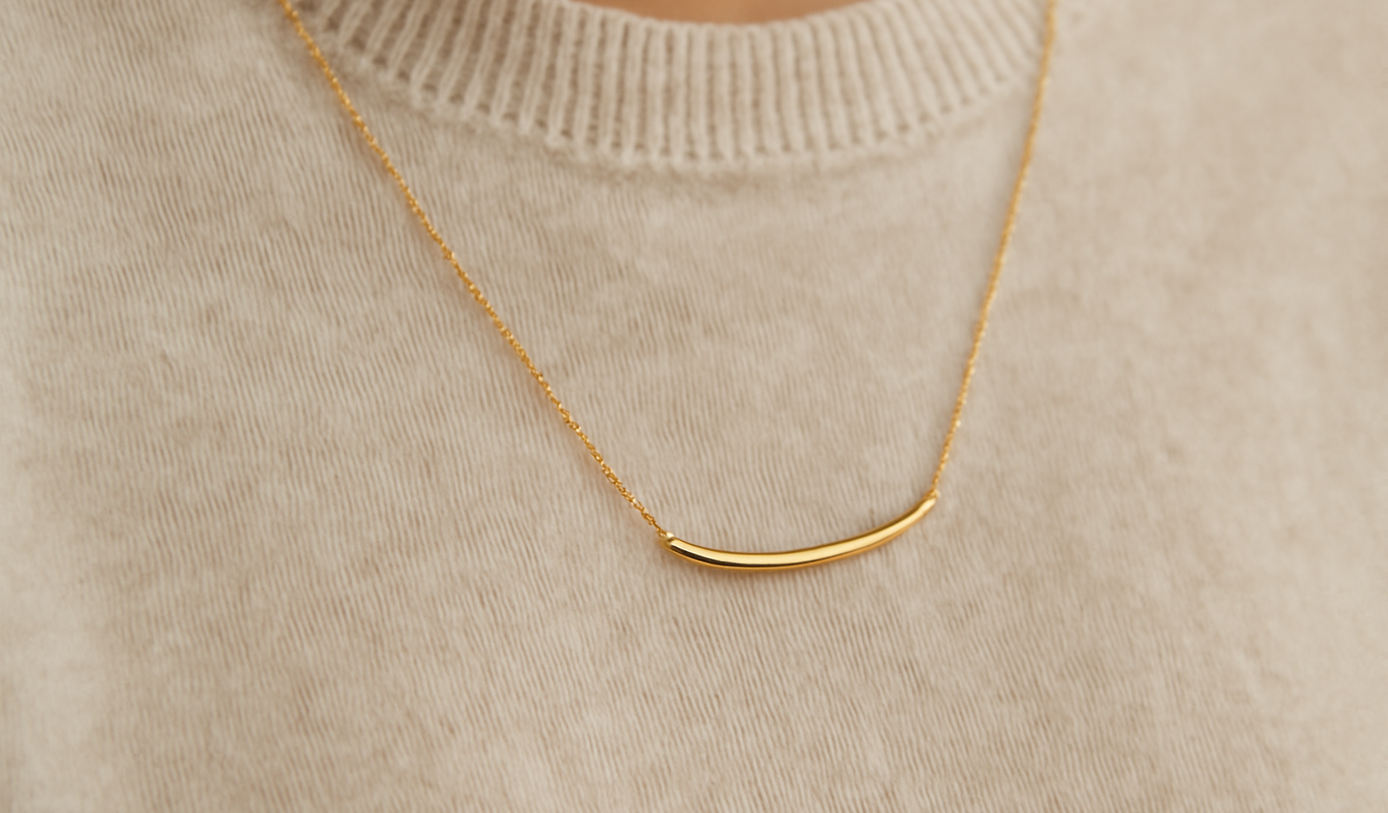 collier minimaliste sur pull monochrome posé