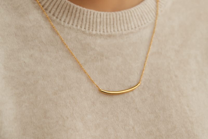 collier minimaliste sur pull monochrome posé