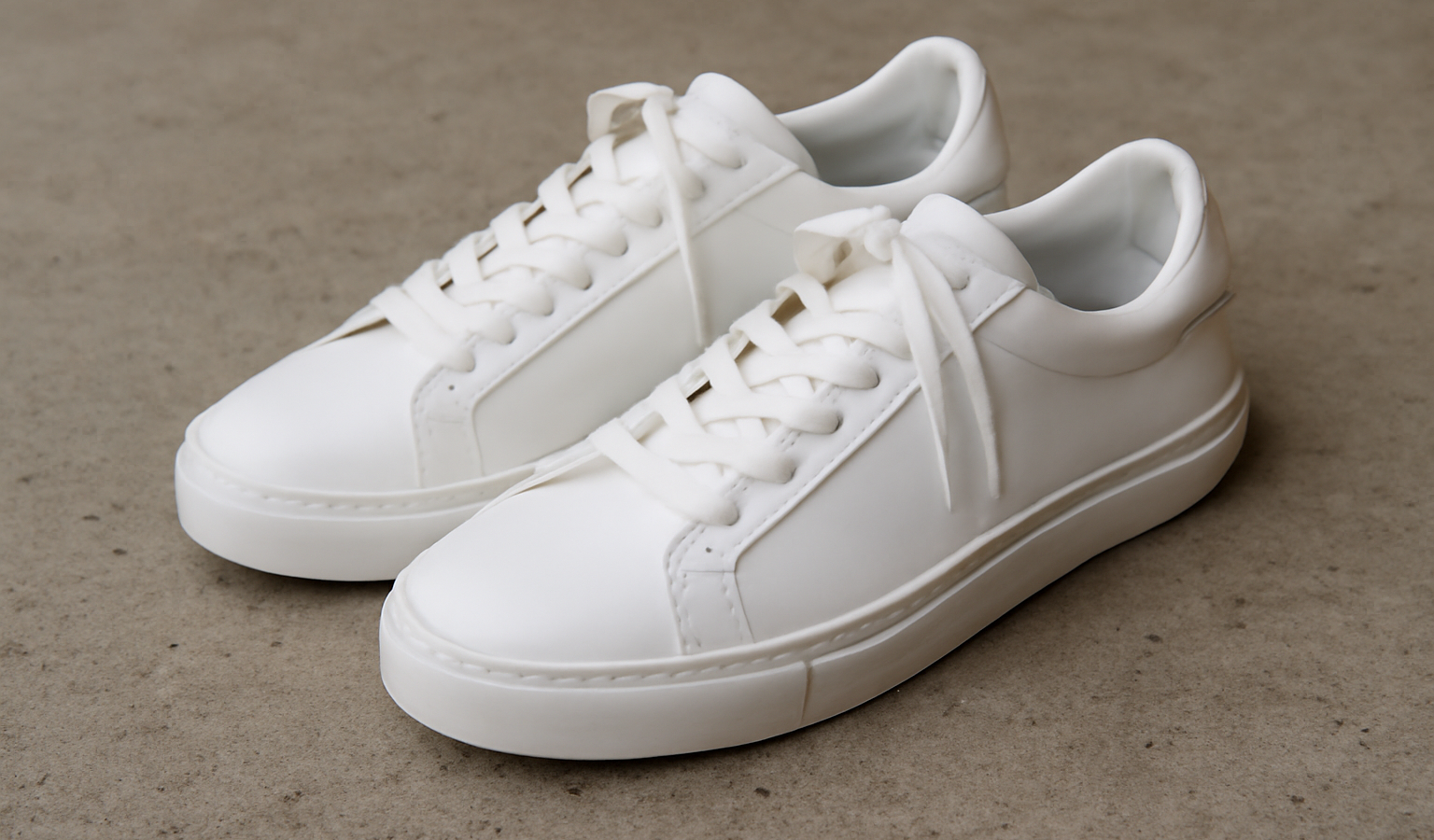 paire de baskets blanches posees sur beton