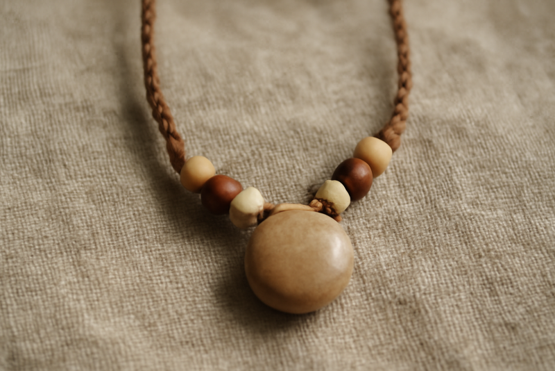 collier artisanal posé sur tissu