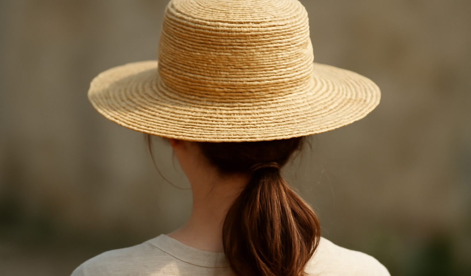 cheveux attachés sous chapeau de paille