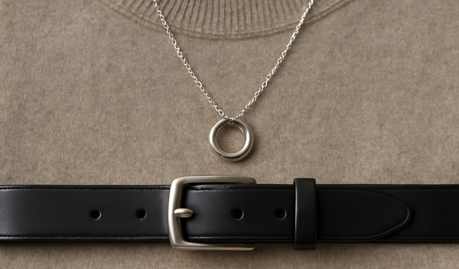 collier et ceinture posés sur pull uni