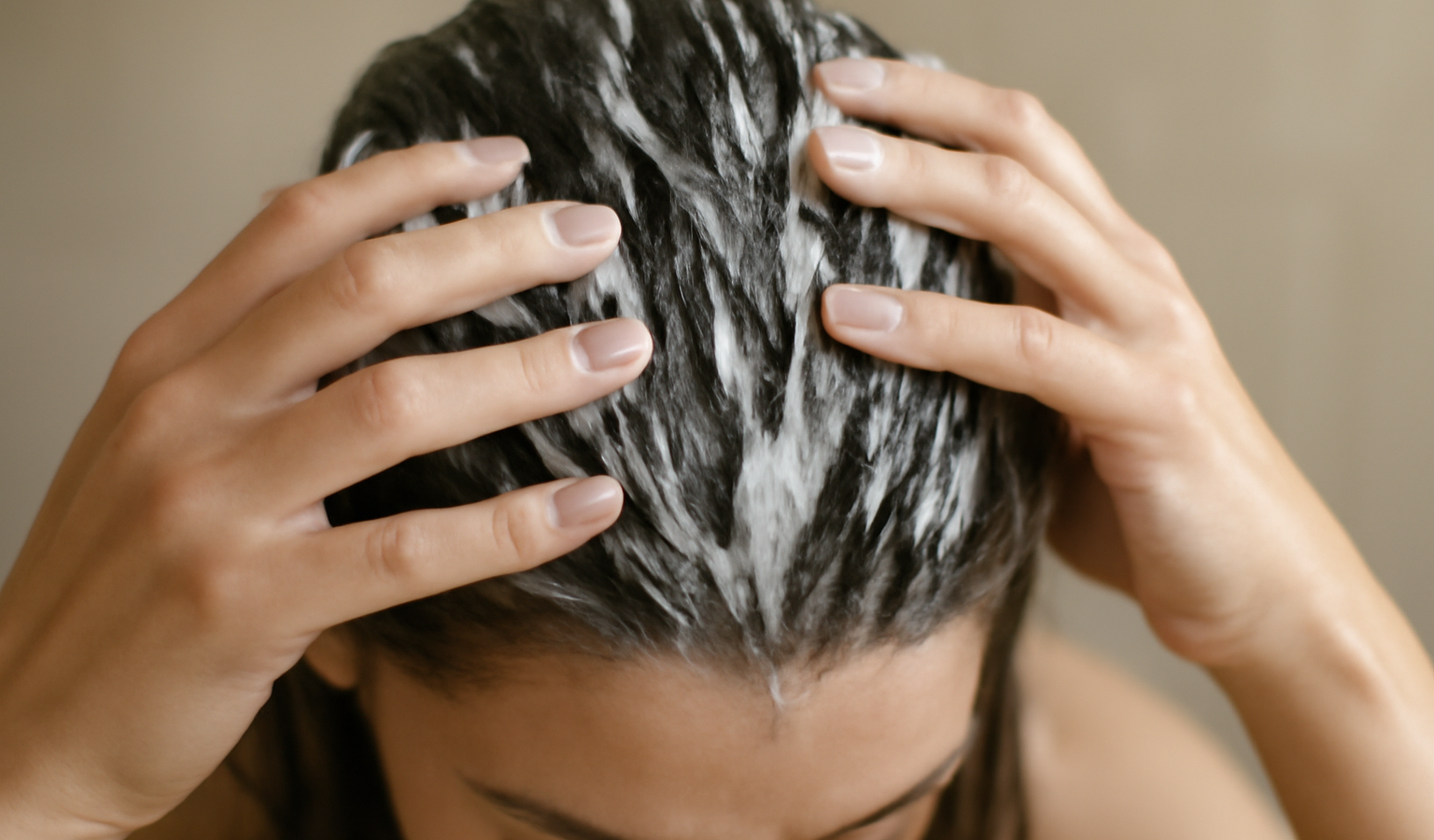 mains appliquant masque sur cheveux mouilles